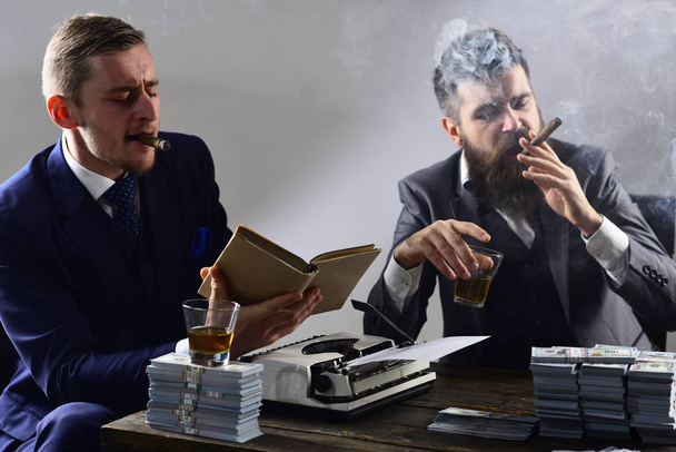 Project management. Businessmen write financial report while drinking and smoking. Business partners with cash money. Money brokers counting profit increase. Successful investment in business - 写真・画像