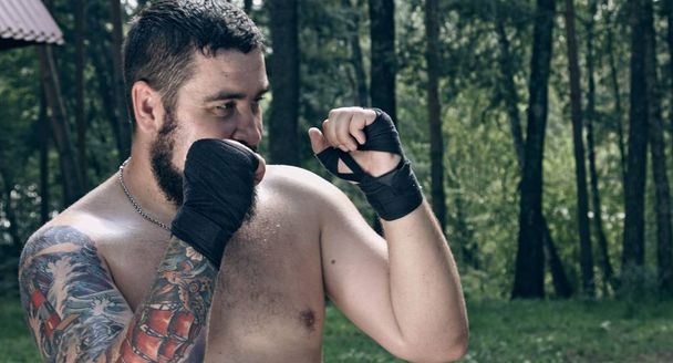 caucasian male boxer posing in forest camp - Foto, afbeelding