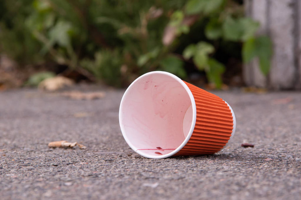 Un vaso de papel vacío debajo de la bebida se encuentra en medio del concepto de contaminación de la calle de pureza con copyspace
 - Foto, Imagen
