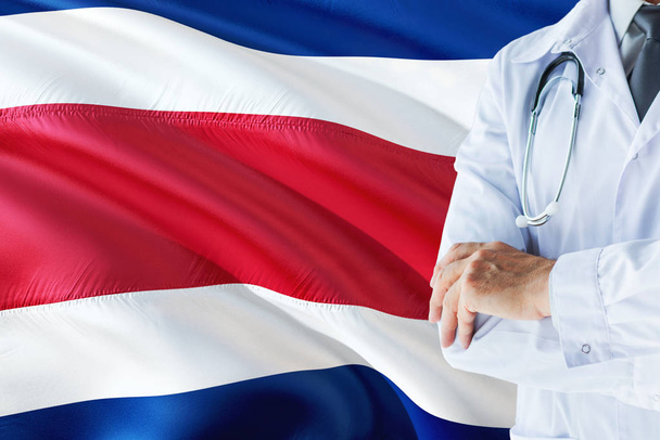 Doctor standing with stethoscope on Costa Rica flag background. National healthcare system concept, medical theme. - Foto, Bild
