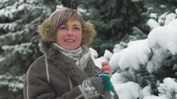 Mujer está posando en el bosque de invierno, hermoso paisaje con abetos nevados
 - Imágenes, Vídeo