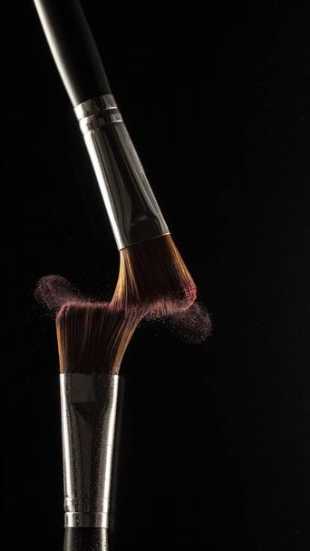 pó respingo e escova para maquiador ou blogueiro de beleza em fundo preto - Foto, Imagem