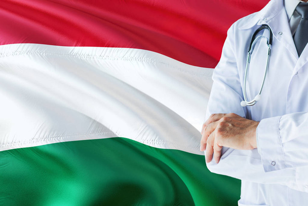 Hungarian Doctor standing with stethoscope on Hungary flag background. National healthcare system concept, medical theme. - Foto, Bild