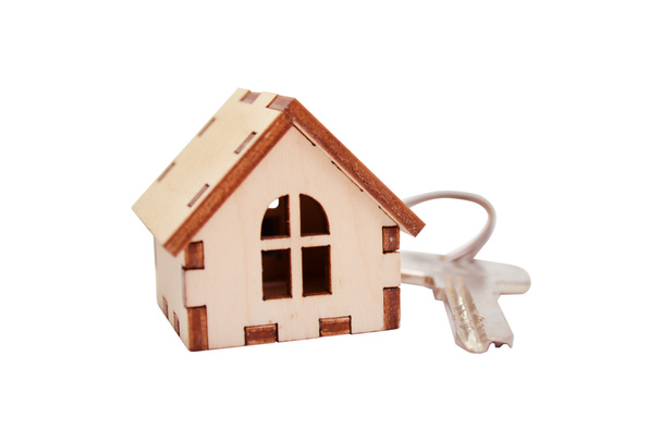 Casa de madeira isolada com chave sobre fundo branco, conceito para vender casas, com um espaço de cópia
 - Foto, Imagem