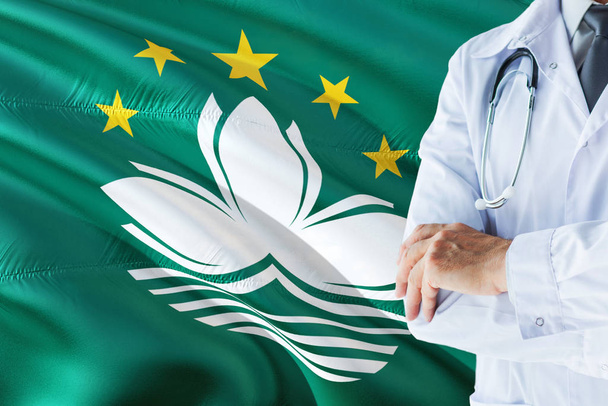 Macau Doctor standing with stethoscope on Macao flag background. National healthcare system concept, medical theme. - Foto, Bild