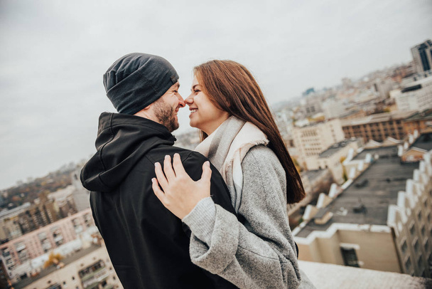 Amante casal abraçando e sorrindo no telhado arranha-céus
 - Foto, Imagem