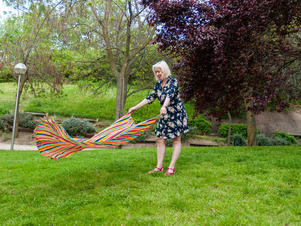 Žena dává ručník na trávu na zeleném trávníku  - Fotografie, Obrázek