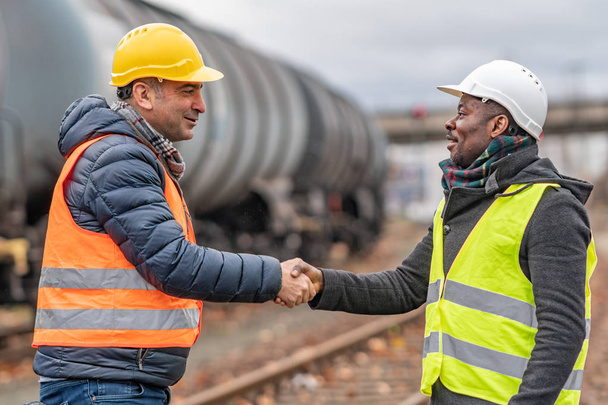 A kézfogás sikeres üzlet: több-etnikumú mérnökök építkezés megállapodásra jussanak - Fotó, kép