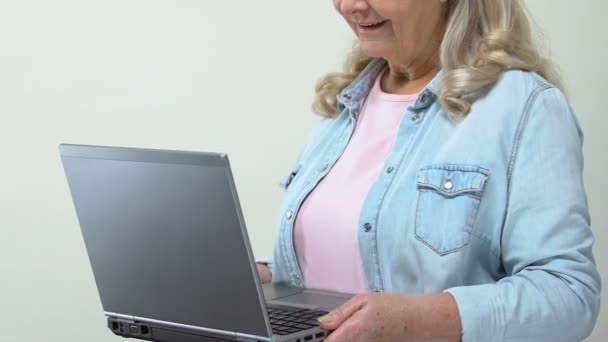 Old female looking shocked receiving email by laptop application, online news - Video, Çekim