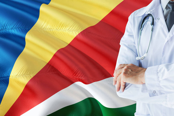 Seychellois Doctor standing with stethoscope on Seychelles flag background. National healthcare system concept, medical theme. - Fotó, kép
