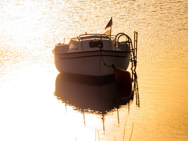 Barco em um lago ao pôr do sol, ancorado no reservatório de La Maya, Espanha
 - Foto, Imagem