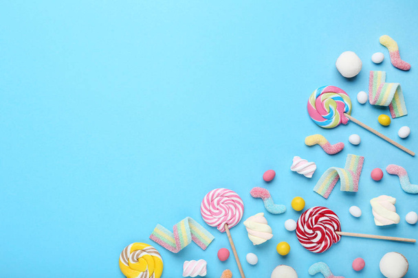 Sweet candies and lollipops on blue background - 写真・画像
