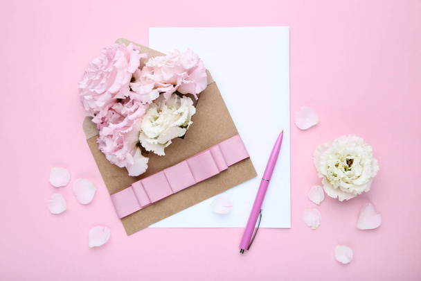 Eustoma flowers with envelope and sheet of paper on pink background - Zdjęcie, obraz