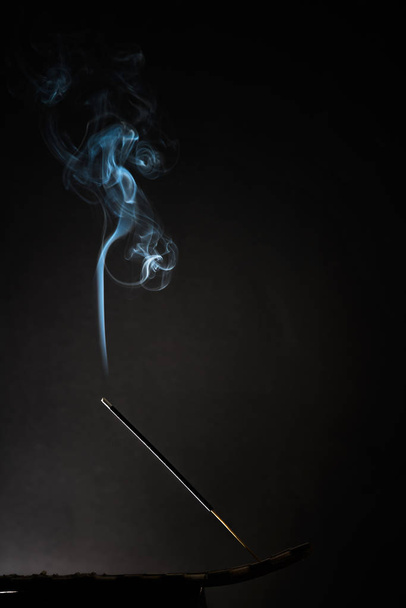 Smoking incense stick with smoke going up on Black Background. Pure relaxation theme, smoke steam, smoke waves, fog and mist effect - Photo, Image