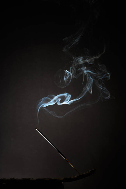 Palenia kadzidła trzymać się dymem, dzieje się na czarnym tle. Czysty relaks tematu, Dym Dym parowy, fale, mgła i mgła efekt - Zdjęcie, obraz