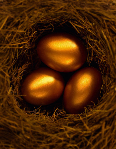 drei goldene Eier im Nest in Nahaufnahme - Foto, Bild
