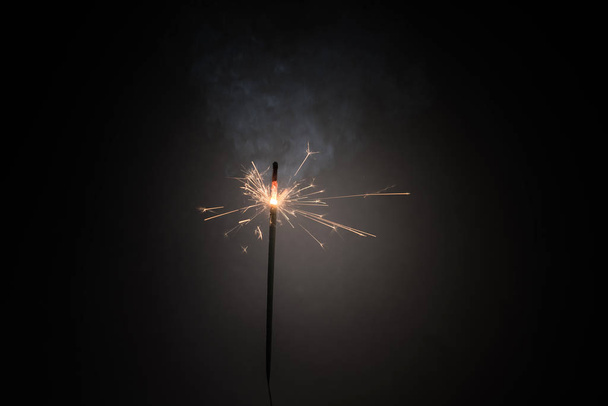Vara de fuego de bengala ardiente Vela de año nuevo chispeante aislada sobre fondo negro. Brillante realista. Bastón de luz mágico. Decoración de Navidad
 - Foto, imagen