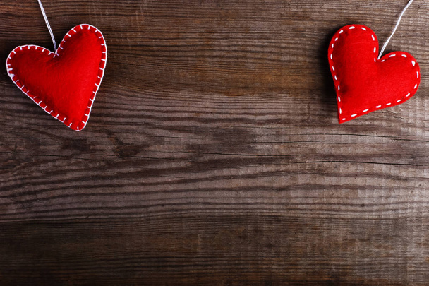Red felt hearts on wooden table. Handmade blank for cards, copy space. - Fotó, kép