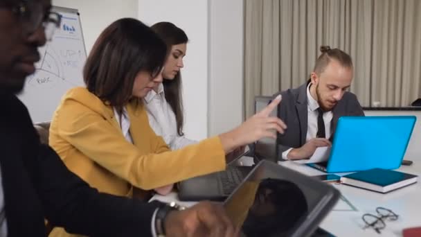 Multi-ethnic group of young business people sitting at the table on conference in the meeting room. A group of mixed business partners discussing in a meeting business development in a conference room - Materiaali, video