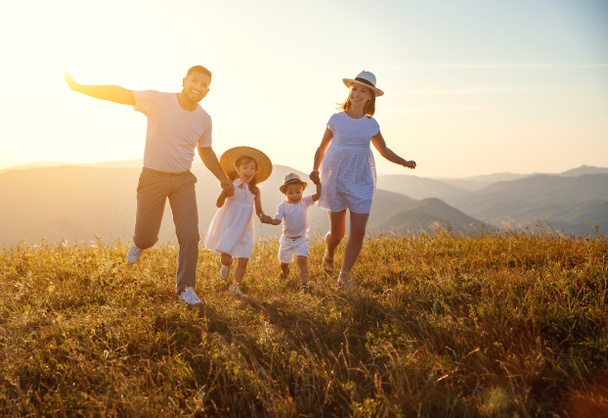 Счастливая семья: мать, отец, дети сын и дочь на природе на закате
 - Фото, изображение