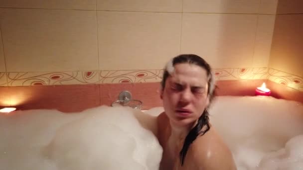 Jovem atraente tomando um banho de espuma queimando velas
 - Filmagem, Vídeo