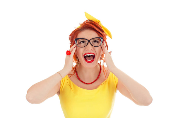 Frustrated confused woman keeping hands in her hair and screaming. Caucasian person in vintage retro yellow dress and coral necklace with red lipstick, redhead hair isolated on white studio background - Photo, Image