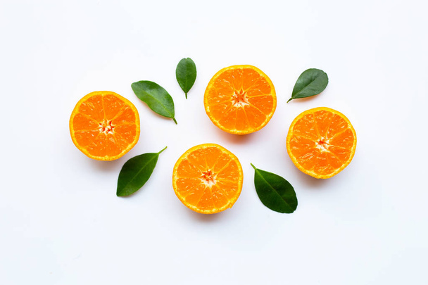 Pomarańczowe owoce z liści na białym tle. Widok z góry - Zdjęcie, obraz