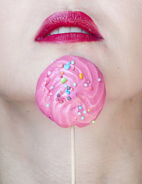 Seksuaalisesti avattu punainen huulet tyttö sokeri lähikuva ja vaaleanpunainen marenki suussa
 - Valokuva, kuva