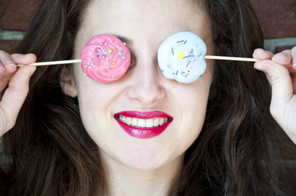 Happy cute lovely brunette young woman with retro style holding birthday meringue lollipop as summer sunglasses - Photo, Image