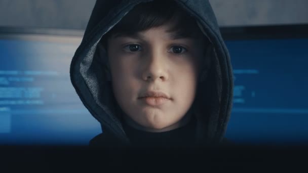 портрет гениального мальчика-хакера вундеркинда в капюшоне на фоне мониторов с программным кодом
 - Кадры, видео