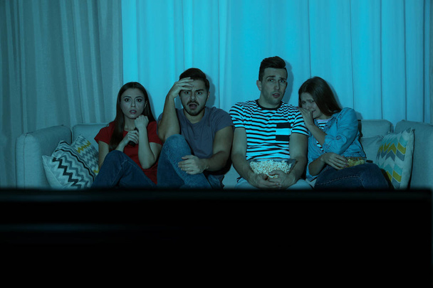 Groupe de personnes regardant la télévision ensemble sur le canapé dans le salon. Espace pour le texte
 - Photo, image