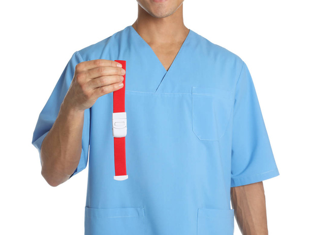Male doctor holding tourniquet on white background, closeup. Medical object - Foto, Imagen