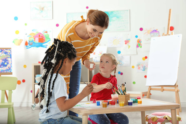 Children with female teacher at painting lesson indoors - Valokuva, kuva