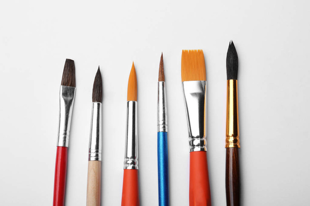 Different paint brushes on white background, top view - Photo, image
