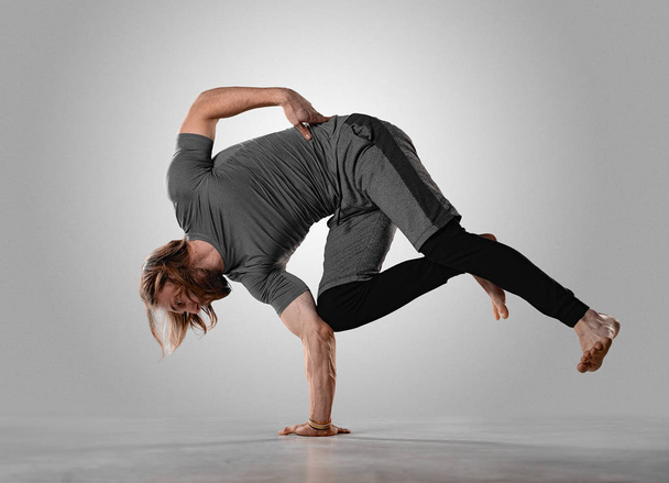 Young hip hop guy performs breakdance acrobatic elements. Man dancing - Foto, imagen