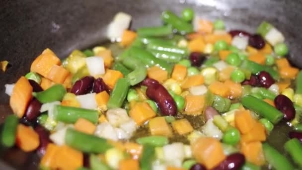 Frozen vegetable mixture is fried in boiling oil. Frying vegetables in a pan. - Footage, Video