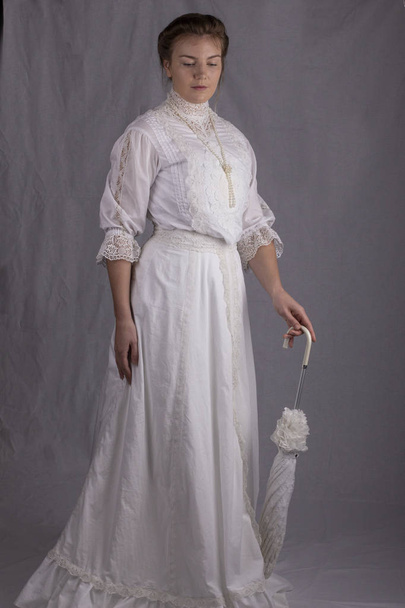 Mujer eduardiana usando un vestido blanco
 - Foto, imagen