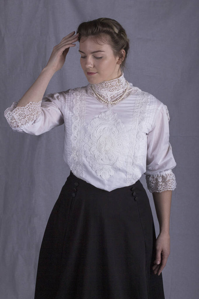 Edwardian woman wearing a white blouse and black skirt - 写真・画像