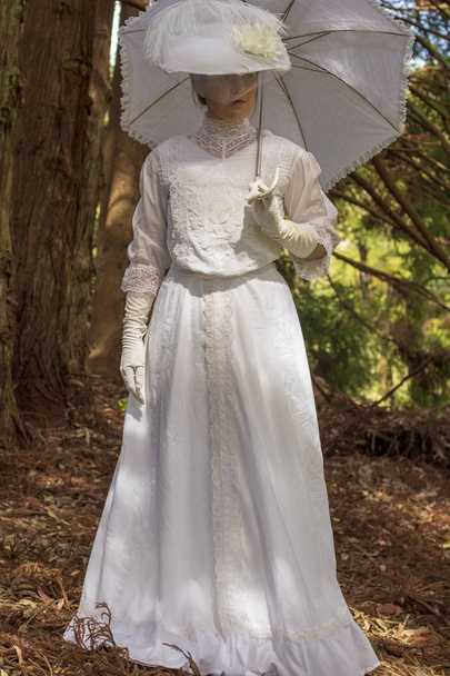 Mujer eduardiana vestida de blanco en el jardín
 - Foto, imagen