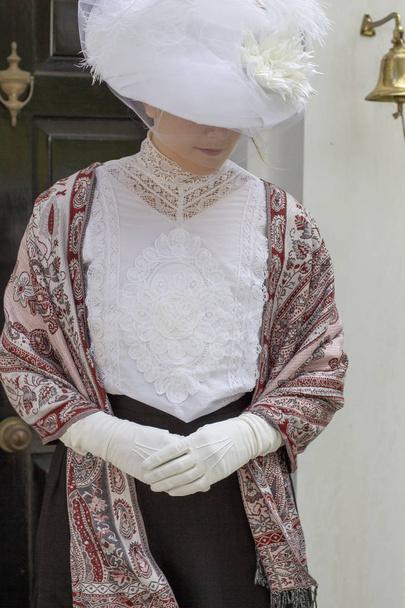 Edwardian kobieta nosi białą sukienkę w ogrodzie - Zdjęcie, obraz