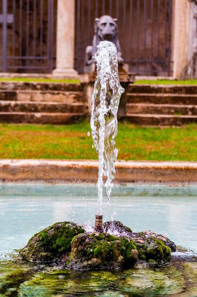 Conception de fontaine en pierre rocheuse avec de l'eau transparente bleu clair reflétant le ciel et la giclée d'eau coule sous pression du centre
 - Photo, image