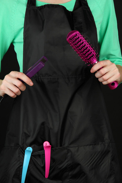 Hairdresser in uniform with working tools, isolated on black - Fotó, kép