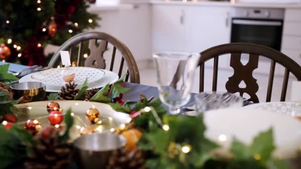 Mid section of a woman laying cutlery at a place setting on a dining table decorated for Christmas dinner, selective focus - Video, Çekim