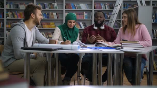 Πολυφυλετικές φοιτητές κάνουν ομάδα μελέτης στη βιβλιοθήκη - Πλάνα, βίντεο