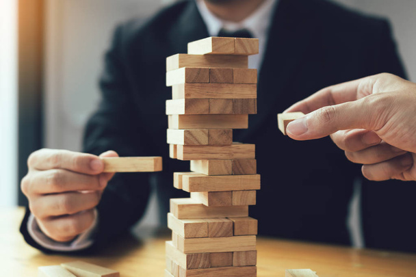 Strategic thinking and risk by business people pulls wooden blocks from the group. - Foto, Imagem