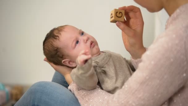 Мама показывает милый зевающий ребенок различные игрушки, раннее развитие младенца
 - Кадры, видео