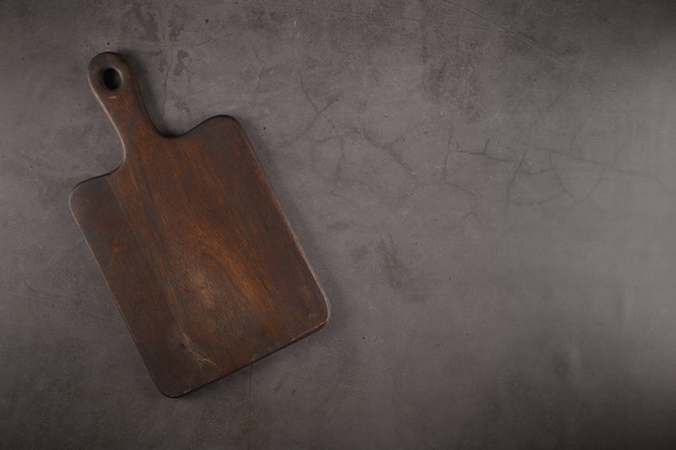 Top view of wooden cutting board on old stone countertop. - 写真・画像