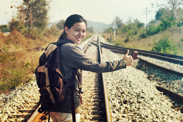 Ταξίδια γυναίκα hitchhiker backpacking ωτοστόπ thumbing ευτυχισμένη περπάτημα σιδηροδρομικών πλευρά κατά τη διάρκεια διακοπών ταξίδια - Φωτογραφία, εικόνα