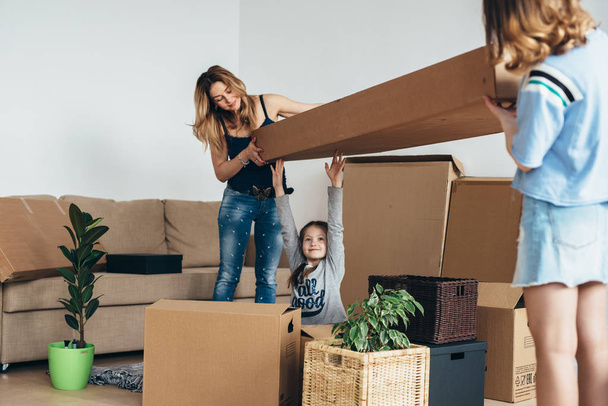 Família com caixas de papelão em casa nova no dia em movimento
 - Foto, Imagem