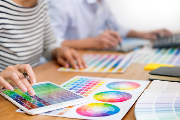 σχεδιαστής γραφικών Δημιουργικός δημιουργικότητα που εργάζονται μαζί χρωματισμό χρήση tablet γραφικών και μια γραφίδα στο γραφείο με συνάδελφο  - Φωτογραφία, εικόνα